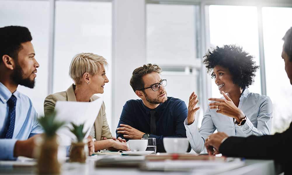 Group of employees meeting at conference table.
